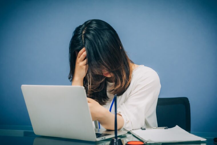 職場でのミスに落ち込み、「また失敗したらどうしよう」と不安を抱えながら、ひとりで自分を責めている女性の様子。