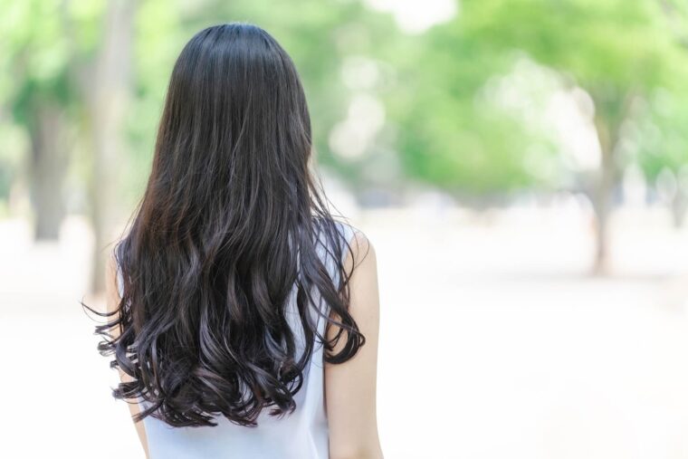 一人静かに立ち尽くし、遠くを見つめる女性の後ろ姿。自分自身と向き合い、心の声を受け止める時間を象徴する。